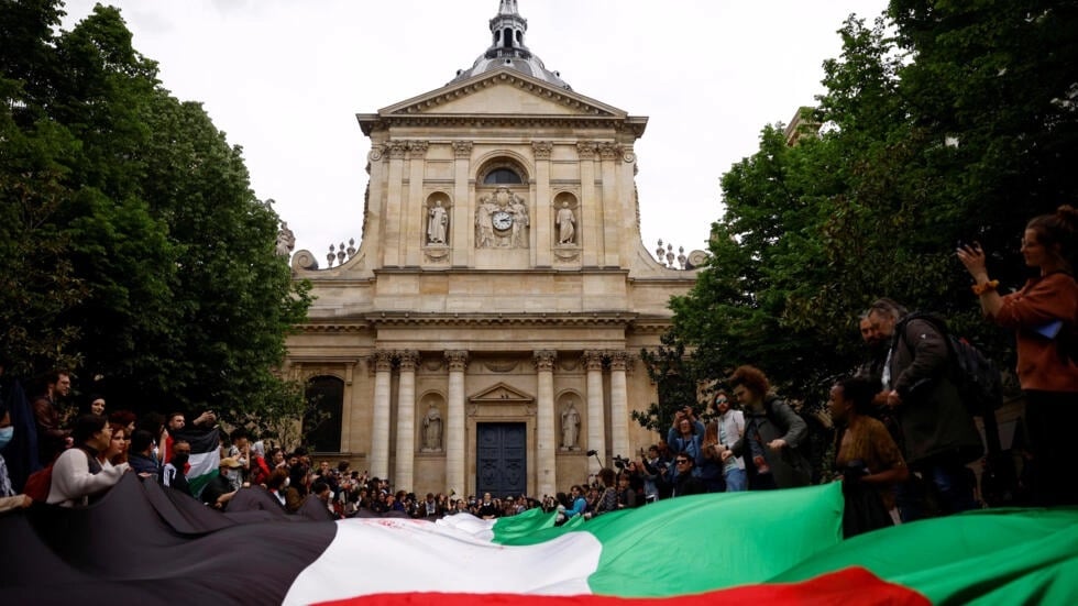 Manifestantes propalestinos sostienen una bandera palestina gigante frente a la Universidad de la Sorbona de París