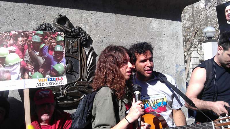 "¡Sólo se mojaron!" los panas Benjamín y Clara lideraron el coro de canciones de Alí Primera cantadas por activistas venezolanos para cerrar la marcha en honor al legado de Chávez.