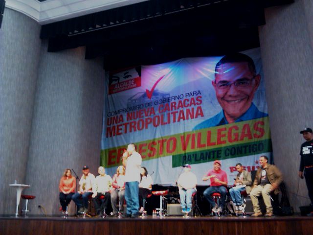 Villegas en el escenario habla al público participante, compuesto por comunicadores y luchadores populares