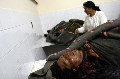 una doctora examina en el depósito de cadáveres de la localidad los cuerpos de obreros abatidos durante los enfrentamientos armados