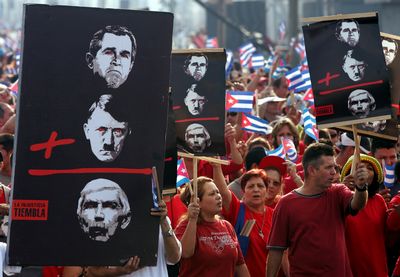 Luis Posada Carriles, en imagen tomada de un programa de televisión transmitido en Miami en mayo de 2005. A la derecha, aspecto de una marcha en enero pasado frente a la oficina de intereses de Estados Unidos en La Habana, para exigir la extradición del anticastrista