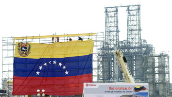 Trabajadores petroleros colocan la bandera venezolana en un complejo petroquímico de ese país. El pasado 1º de mayo empezó a regir la nacionalización de las reservas de la Faja del Orinoco.