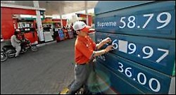 Un empleado de una gasolinera de Karachi, en Pakistán, cambia los precios de los carburantes
