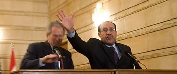 Al Maliki trata de detener uno de los zapatos arrojados contra Bush
