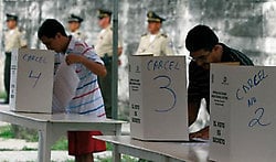 Dos convictos votan en la Penitenciaría de Guayaquil, en el inicio de la jornada de comicios generales que culminará este domingo.
