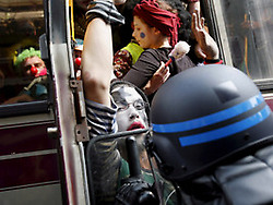 Policías franceses empujan a manifestantes disfrazados de payasos, al interior de un autobús en Neuhof.