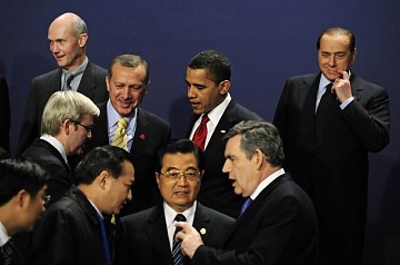 El primer ministro Gordon Brown (abajo a la derecha) conversa con el presidente chino, Hu Jintao (al centro, con un traductor) en la cumbre del G-20 este jueves. El primerministro italiano, Silvio Berlusconi (arriba a la derecha) observa mientras se chupa el dedo. También aparecen (arriba, desde la izquierda) el Director General de la OMC, Pascal Lamy; el primer ministro australiano, Kevin Rudd; el primer ministro turco, Tayyip Erdogan, y el estadounidense Barack Obama.