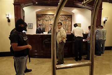 Policías encapuchados amedrentando a los periodistas dentro del hotel donde se alojaban