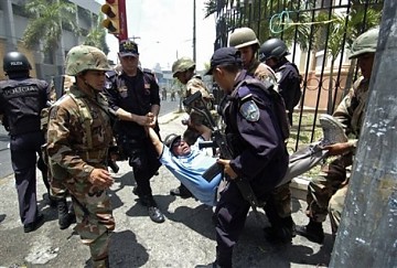 Soldados hondureños llevan a la rastra a un detenido