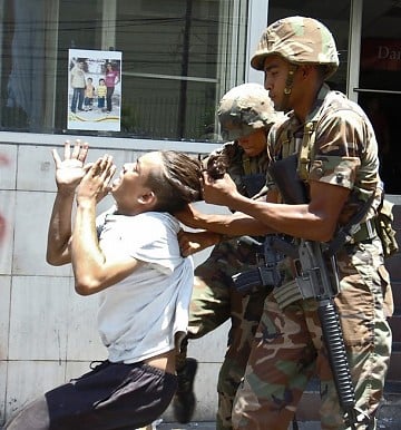 Las fuerzas militares arrestan de los pelos