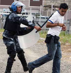 Policía en pleno acto de golpear a un reportero gráfico en Honduras
