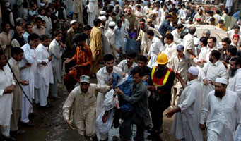 Pakistaníes socorren a algunos heridos como consecuencia de una explosión de un carro bomba. (Foto: Efe)