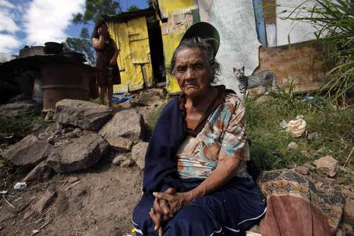 María Cristina Rivera, de 86 años, descansa afuera de su pobre vivienda de la periferia de Tegucigalpa