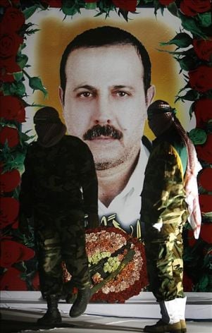 Un grupo de militantes del grupo Hamas posa junto a una fotografía del asesinado comandante militar de Hamas, Mahmoud al-Mabhouh,