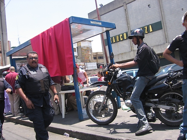 Policía custodiando el toldo de propaganda a favor de Freddy Bernal colocado en una parada de transporte público