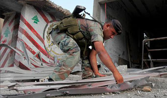 Un soldado libanés recoge los escombros que dejó el ataque israelí contra una garita fronteriza.