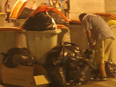 Un hombre busca en la basura en un barrio céntrico de Madrid - E.M.
