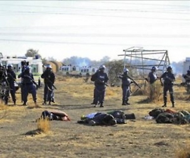 Unos policías inspeccionan los cuerpos de los mineros muertos tras los tiroteos acontecidos cerca de una planta minera en Rustenburgo, Sudáfrica