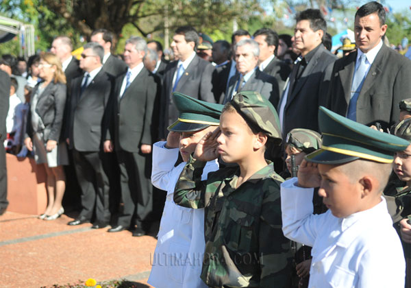 niños uniformados y portando armas de juguete en un desfile en Paraguay