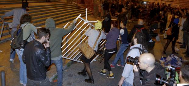 Manifestantes tratan de tumbar una barrera durante la manifestación ante el Parlamento