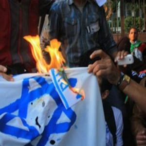 Palestinos queman una bandera israelí en protesta contra los bombardeos.