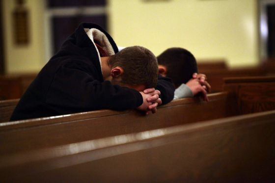 Dos personas rezan en una iglesia cercana a la escuela donde se produjo la matanza.