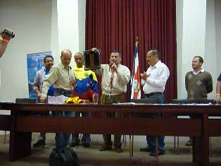 Momento en que Eduardo Medina del Circulo Bolivariano Hugo Chávez Frías, muestra la placa entregada por la ANEP como Homenaje Póstumo al Comandante Chávez