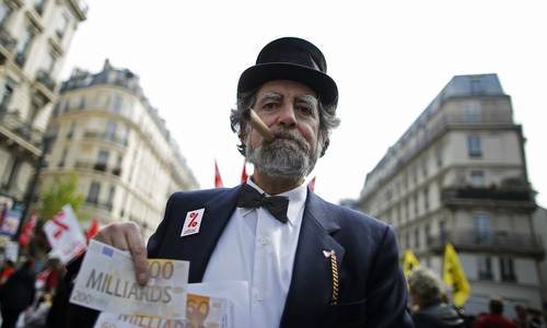 Un participante en la movilización francesa disfrazado de banquero