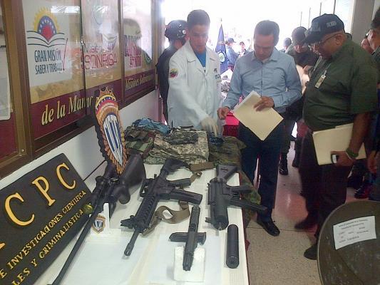 El gobernador del estado Táchira, José Gregorio Vielma Mora inspecciona el moderno armamento confiscado al detenido.