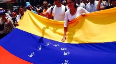 María Corina Machado se burla de la Bandera Nacional Venezolana en la que fueron sustituidas las estrellas por manos blancas del golpismo