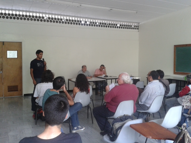 César Romero, militante de la Juventud de Marea Socialista, junto al panel y los asistentes a la actividad