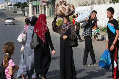 Palestinos huyen de sus hogares hacia una escuela de las Naciones Unidas en busca de refugio este domingo