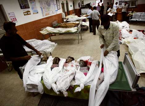 Médicos palestinos amortajan en un hospital los cuerpos de varios niños que perecieron durante los cruentos ataques israelíes en la franja de Gaza. Ayer fue la jornada más sangrienta al cumplirse el día 22 de la ofensiva contra Hamas
