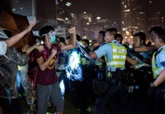 Protestas pro democracia en Hong Kong: un manifestante le enseña el puño a un policía el 15 de Octubre