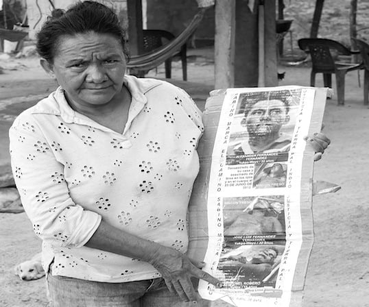 Carmen Anita Fernandez, mostrando una galería de imágenes de su hijo Alexander Fernández, vilmente asesinado por sicarios