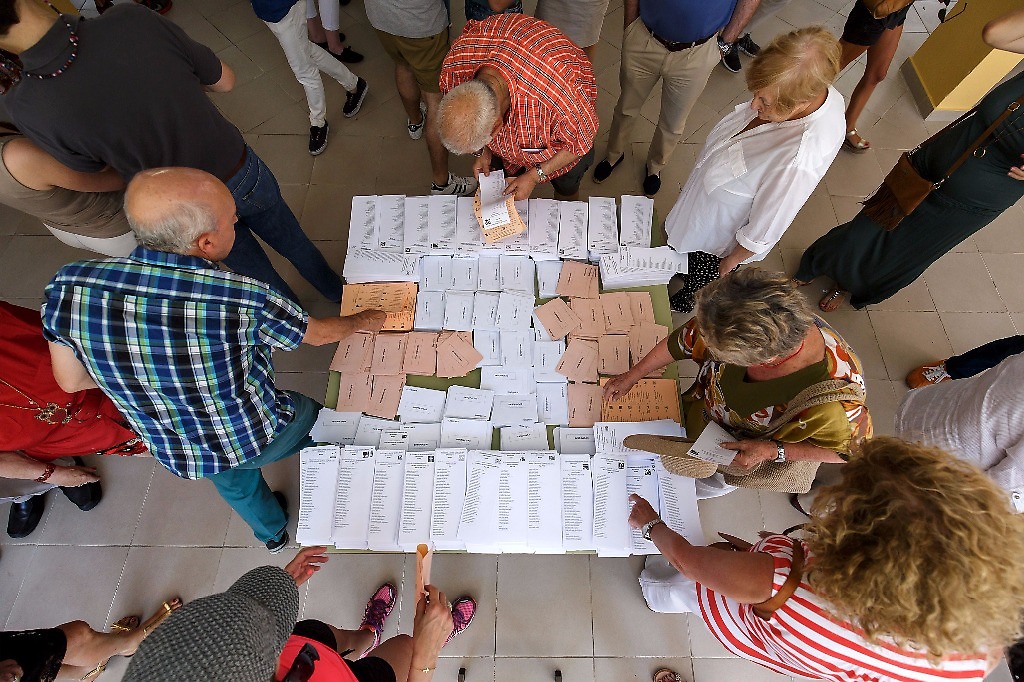 Españoles reúnen las boletas para participar en las elecciones generales al interior del Colegio Bernadette, en Moncloa – Aravaca, Madrid. 