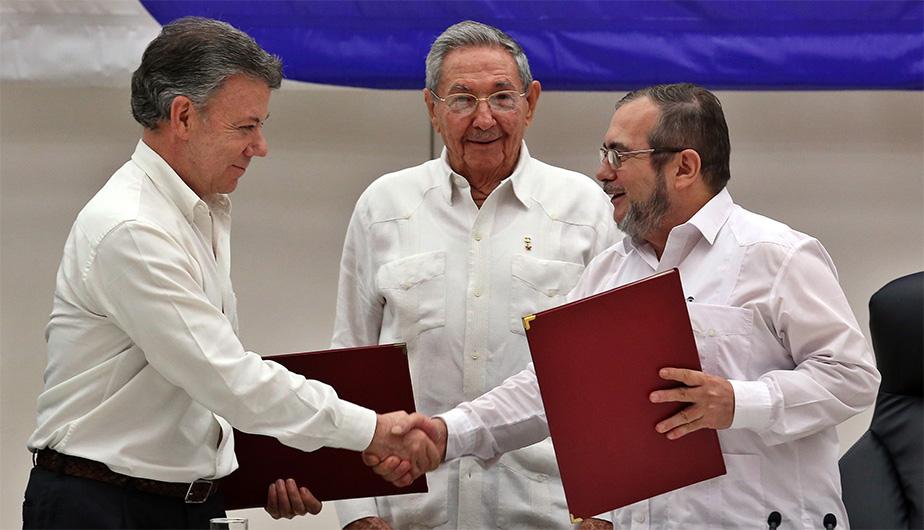El presidente de Colombia, Juan Manuel Santos, y el líder de las FARC, Timochenko, se dan la mano tras la firma del acuerdo de paz
