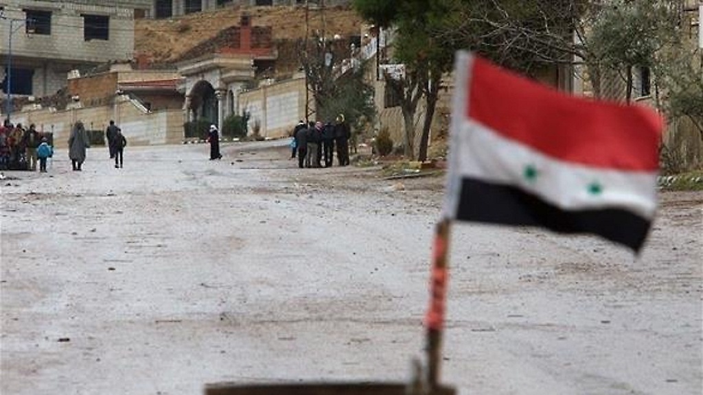 La bandera siria aparece como retando a los grupos violentos