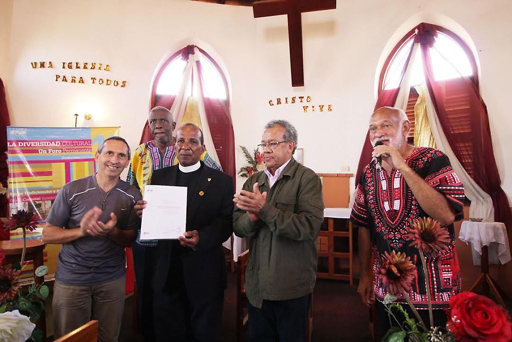 Benito Irady entrega el reconocimiento del MPPC al Reverendo Adams Delgado Marksman