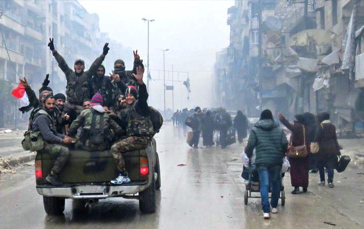 Las fuerzas progubernamentales de Siria pasan por las zonas residenciales del barrio alepino de Bustan al-Qasr, libre de la presencia de los terroristas, 13 de diciembre de 2016.