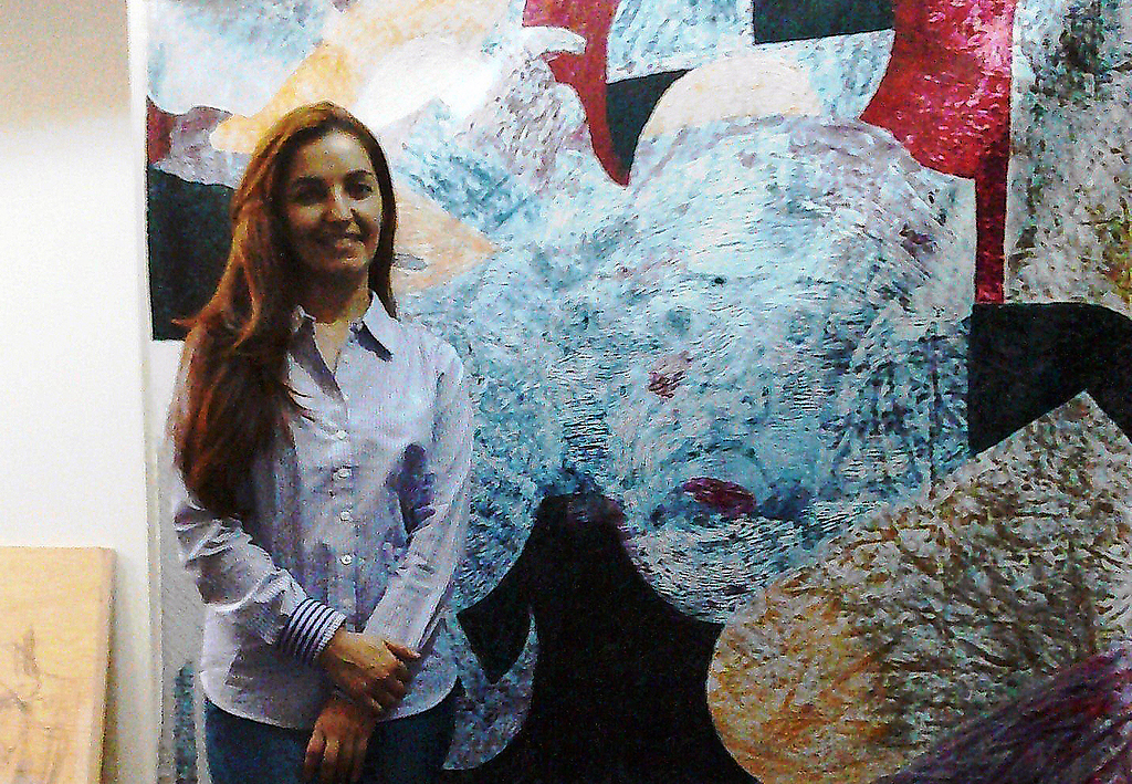 La artista tachirense Ana Yudith posa frente a una de sus pinturas.