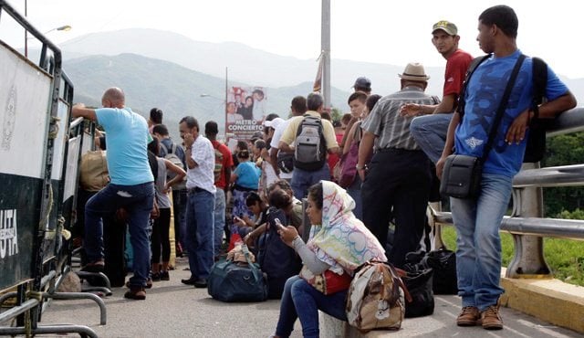 Ciudadanos colombianos y venezolanos se mezclan entre la multitud que espera poder cruzar para cumplir con sus actividades respectivas.