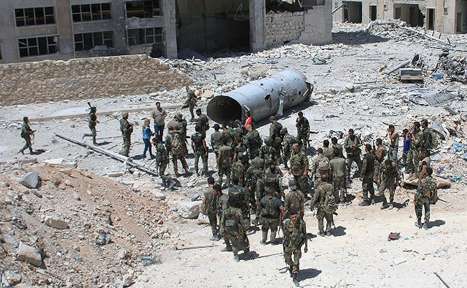Soldados del ejército sirio patrullan el área alrededor de la entrada de Bani Zeid, en la periferia de Alepo.