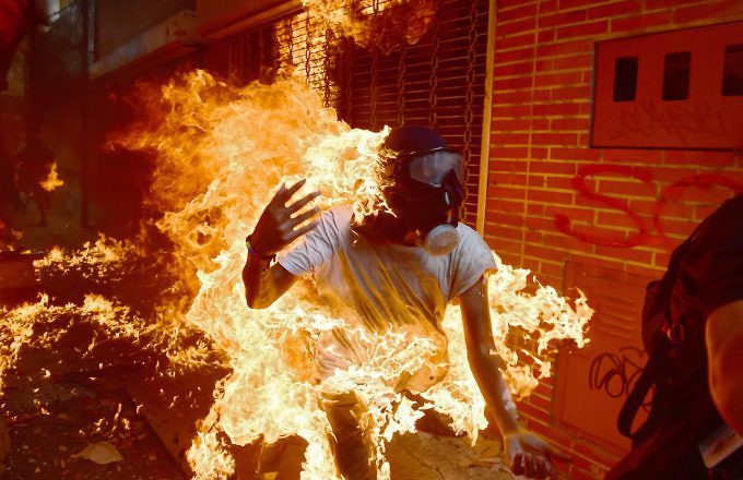 Manifestante envuelto en llamas durante protesta violenta opositora en el este de Caracas.