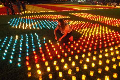 Una mujer enciende una de las miles de velas en apoyo al referendo en Cataluña