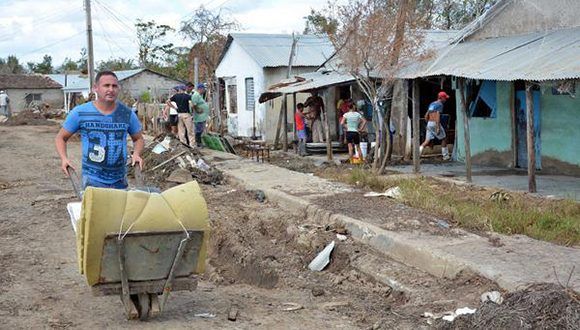 Un poblador traslada un colchón expuesto al sol, en Palmarito, comunidad más afectada por el huracán Irma en el poblado de Júcaro, del municipio Venezuela, como parte de la recuperación en Ciego de Ávila. 