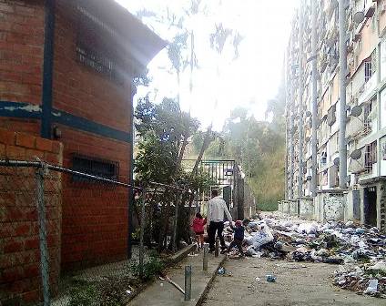 Montaña de basura que obstaculiza el paso a los transeúntes, justo frente a un módulo de salud de Barrio Adentro