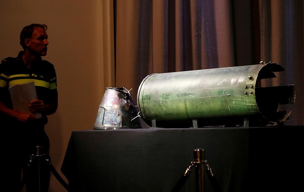 Un misil dañado es mostrado en la conferencia del equipo de investigación sobre la tragedia del vuelo de Malaysia Airlines.