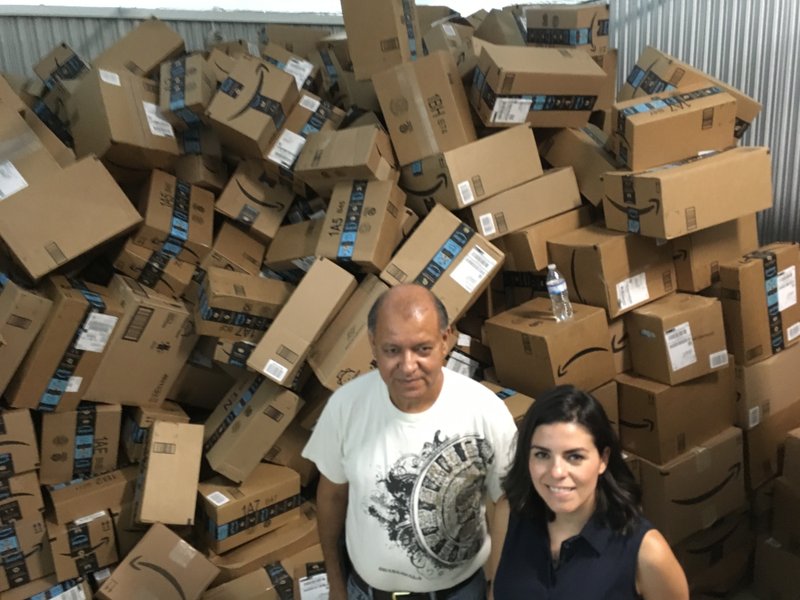 Eli Fernández, miembro de la organización Catholic Charities of the Rio Grande Valley, y la voluntaria Natalie Montelongo frente a una pila de cajas sin ordenar con donaciones enviadas a través del servicio de Amazon, en McAllen, Texas