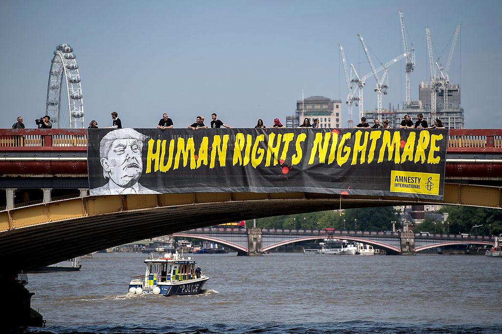 Activistas de Amnistía Internacional cuelgan una pancarta contra Trump en Vauxhall Bridge, frente a la embajada de los EE.UU., la pancarta dice, "La pesadilla de los derechos humanos"